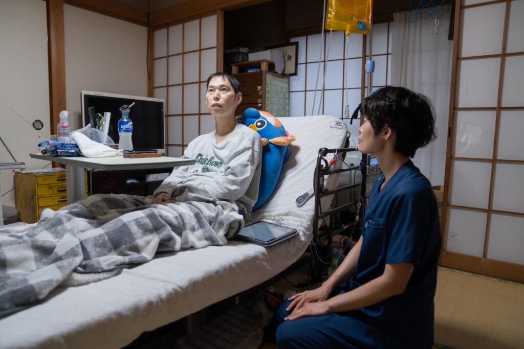 ベッドに座る男性と女性医師