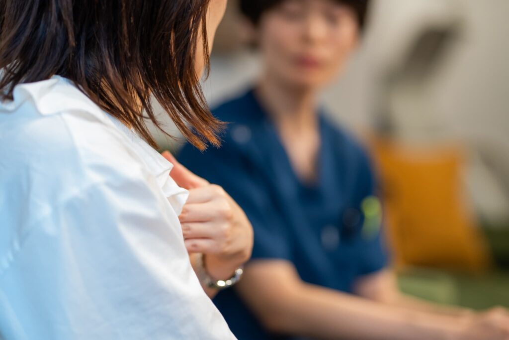 胸に手を当てる女性