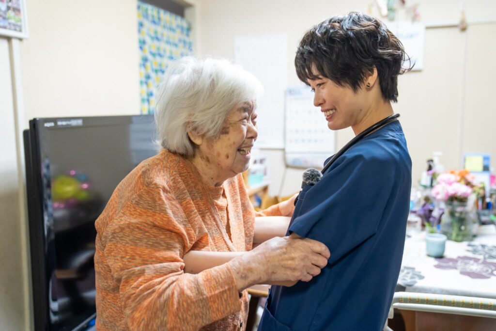 嬉しそうに笑う高齢の女性と女性医師