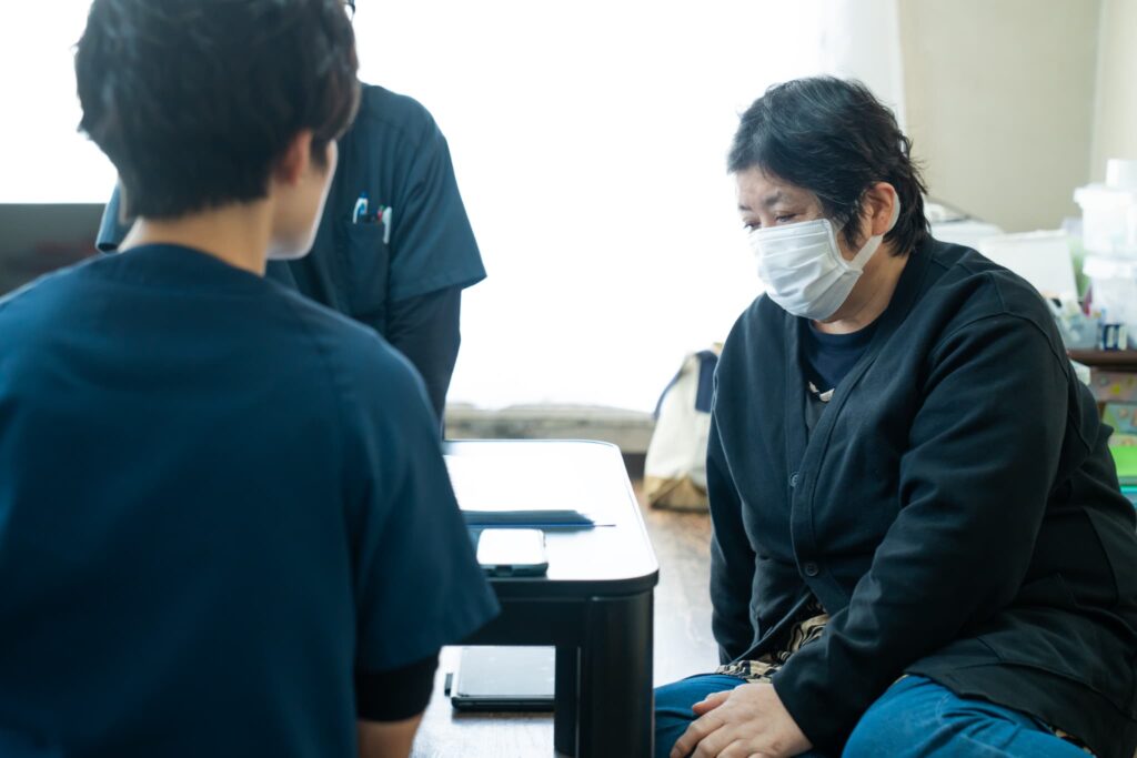 マスクをつけた女性と女性医師の後ろ姿