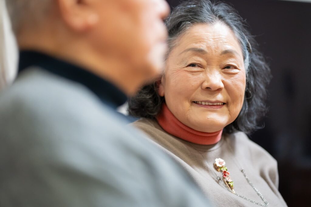 笑顔で夫を見る高齢女性