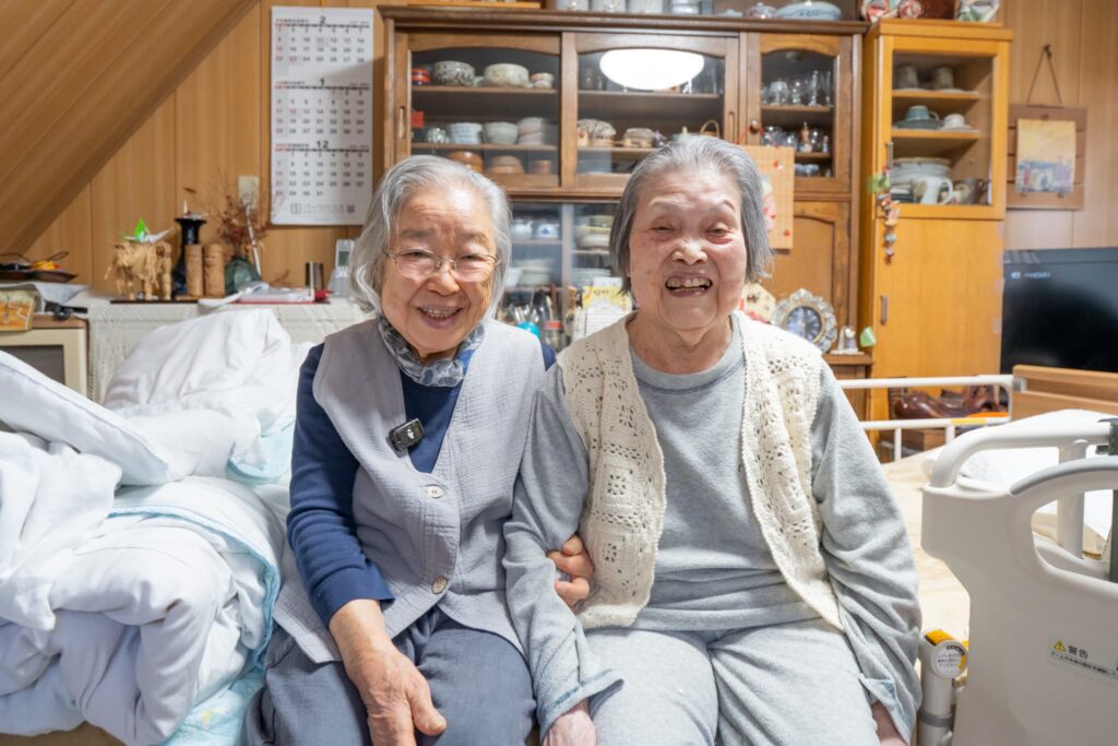 仲良く座る高齢の女性二人