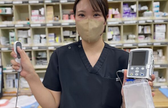 携帯型精密輸液ポンプを持つ位女性看護師